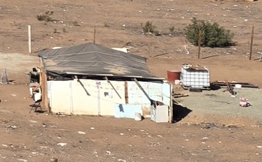 Dirt floor and a tarp roof.